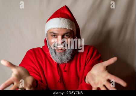 Le Père Noël se tient devant la caméra avec son les bras larges s'ouvrent et vous invite à un câlin avec un grand sourire Banque D'Images