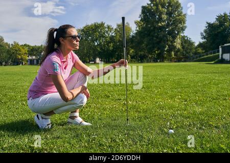 Sportswoman se préparant à jouer une partie de golf Banque D'Images