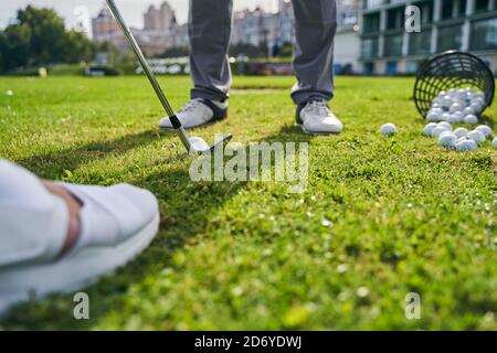 Entraîneur instruisant un golfeur débutant à frapper le ballon Banque D'Images