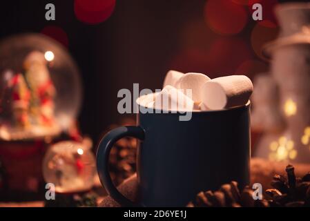 Encore la vie. La tasse avec guimauves sur un fond de lumières colorées. En arrière-plan sont des jouets sous forme de boules de verre. Banque D'Images