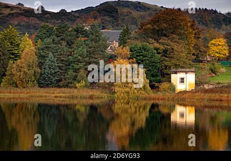 Duddingston Loch Edinburgh, Écosse, Royaume-Uni. 20 octobre 2020. Nuageux avec une température de 10 degrés avec peu de brise. Photo : en automne, le Loch Duddingston avec la Tour de Thomson réfléchie en premier plan et Duddingston Kirk niché dans les arbres à feuilles persistantes du conifères du jardin du Dr Neil. La tour conçue par William Henry Playfair construite en 1825 pour que la Duddingston Curling Society stocke ses pierres. Un lieu de rencontre pour les conservateurs et un studio pour l'artiste respecté le Rév. John Thomson, ministre de Duddingston de 1805 à 1840. Crédit : Arch White/Alamy Live News. Banque D'Images