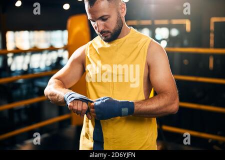 Personne athlétique concentrée qui se lie à la main droite Banque D'Images