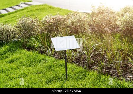 Vider le panneau d'affichage sur l'herbe avec de l'espace pour la légende. Maison de la propriété à vendre panneau d'affichage. Tableau d'affichage avec espace de copie pour interdiction Banque D'Images