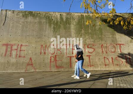 Les gens se promonnent devant les graffitis en lisant « le nord n'est pas une boîte de Petri » à Manchester, alors que le gouvernement se prépare à imposer de nouveaux contrôles stricts contre le coronavirus à 2.8 millions de personnes après que les discussions avec les dirigeants locaux du Grand Manchester n'aient pas abouti à un accord. Les dirigeants ont été donnés jusqu'à midi mardi pour parvenir à un accord, ou pour faire face à une action unilatérale du gouvernement, après 10 jours de négociations n'ont pas réussi à parvenir à un accord. Banque D'Images