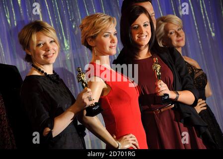 Employés Laura Burks (à gauche) et Gemma Keegan (à droite) photographiés avec les statues des lauréats Kate Weinslet et Dame Helen Mirren lors de l'ouverture de la saison des récompenses à Madame Tussauds à Londres. Banque D'Images