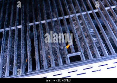 Vue rapprochée des grilles en fonte d'un gril à gaz extérieur. Banque D'Images