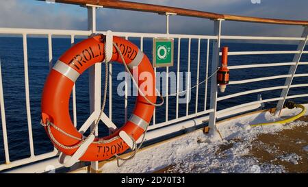 Sørøysundet, Norvège - 03/02/2019: Ceinture de vie de couleur orange avec le nom du navire monté sur la rambarde du pont supérieur du navire de croisière Hurtigruten. Banque D'Images