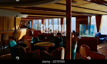 Sørøysundet, Norvège - 03/02/2019: Design intérieur d'un bar sur le bateau de croisière Hurtigruten (RoRo ferry) MS Trollfjord avec chaises, tables et décoration. Banque D'Images