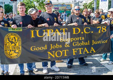 Miami Florida,Biscayne Boulevard,zone de libre-échange des Américains Summit manifestations de la ZLEA,les manifestants signent la bannière membres du syndicat IUPAT, Banque D'Images