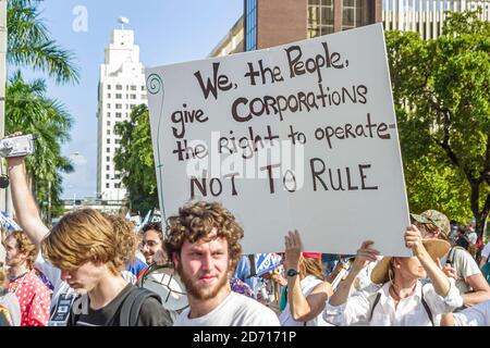 Miami Florida,Biscayne Boulevard,zone de libre-échange des Américains Summit manifestations de la ZLEA, les manifestants tiennent une affiche de la cupidité de l'entreprise, Banque D'Images