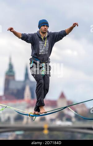 Un marcheur en corde raide au-dessus de la Vltava avec un panorama sur le château de Prague, république tchèque Banque D'Images