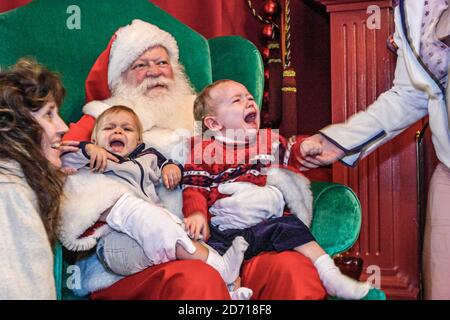 Virginia Norfolk MacArthur Center Mall, Santa Claus tient des bébés pleurs bébé tout-petits, homme homme costume homme tenue mère essayant essais comfo Banque D'Images