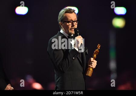 Gary Oldman accepte le Brit Icon Award au nom de feu David Bowie sur scène lors des Brit Awards 2016 à l'O2 Arena, Londres. Banque D'Images