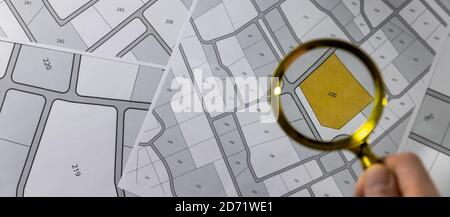 main avec loupe sur carte cadastre - recherche et acheter concept de terrain. bannière copie espace Banque D'Images