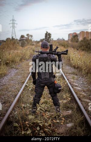 un homme avec un fusil en uniforme tient avec lui retour Banque D'Images