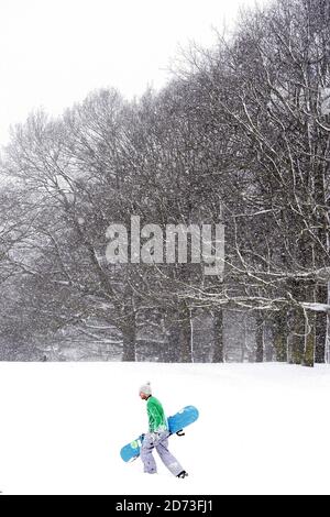 Un snowboardeur sur Hampstead Heath après de fortes chutes de neige ferme les écoles et provoque le chaos des transports à Londres. Banque D'Images