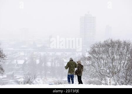 Les gens s'entaffent sur Hampstead Heath après que la neige abondante ferme les écoles et provoque le chaos des transports à Londres. Banque D'Images