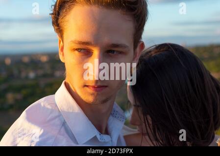 gros plan portrait d'un gars avec une fille, sur fond de soleil couchant, soirée d'été. un gars avec une fille, un jeune couple de vingt-deux ans o Banque D'Images