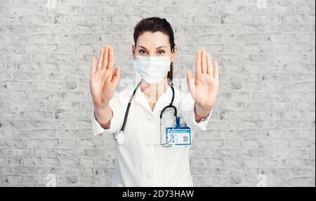 Médecin femme fait un geste de main d'arrêt. Fille Docteur portant un masque de protection contre le covid-19. Bannière panorama personnel médical équipement préventif Banque D'Images