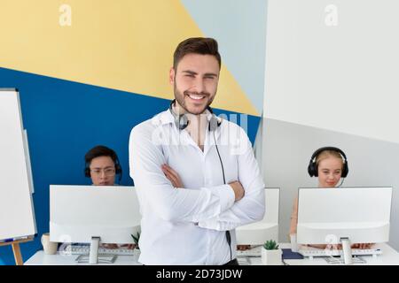 Portrait d'un représentant positif du service clientèle et de ses collègues au centre d'appels contemporain Banque D'Images