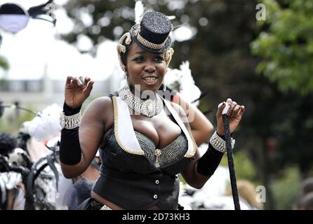 Les fêtards suivent les flotteurs au Notting Hill Carnival le lundi de la fête de rue de 3 jours dans le nord-ouest de Londres. Banque D'Images