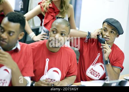 JLS man les téléphones pendant le ont un appel de coeur, à l'aide de Starlight Children's Foundation, aux studios de radio globale dans le centre de Londres. Banque D'Images