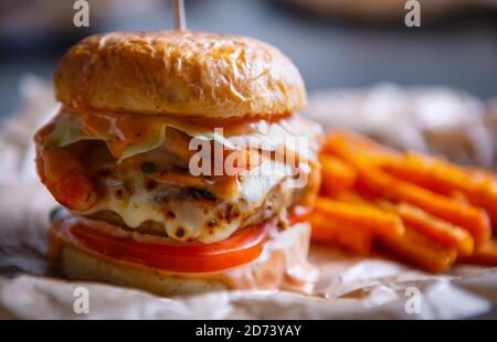 Hamburger Delicous avec côtelettes de viande de bœuf servi sur plaque restaurant de restauration rapide. énorme double hamburger avec frites Banque D'Images