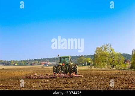 Le tracteur herme sur un champ au printemps Banque D'Images