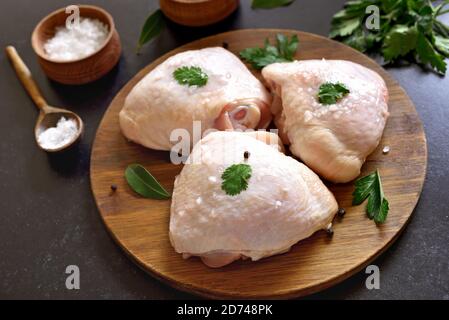 Cuisse de poulet crue sur planche à découper en bois Banque D'Images