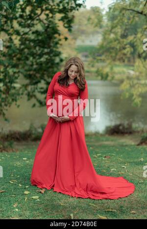 Femme vêtue d'une robe rouge pour les photos de maternité Banque D'Images