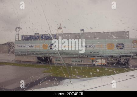 Aéroport de Francfort :aéroport international de Francfort vue non ciblée depuis la fenêtre de l'avion avec gouttes d'eau sur le verre par temps pluvieux Banque D'Images