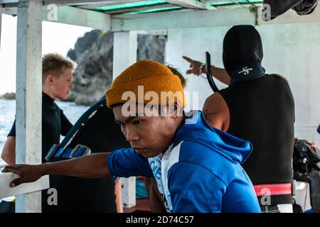 Îles Calventuras, Ngwesaung, Myanmar, 29 décembre 2019 : portrait d'un homme birman local en face de quelques plongeurs sur un bateau Banque D'Images