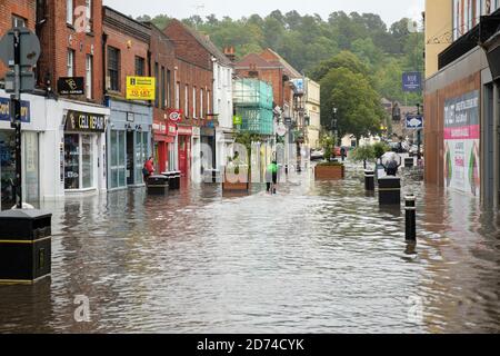 Winchester, Angleterre, Royaume-Uni 27/08/2020 UN cycliste qui traverse les eaux d'inondation sur la rue High à Winchester après de lourds dégrins dus à la tempête Francis. Banque D'Images