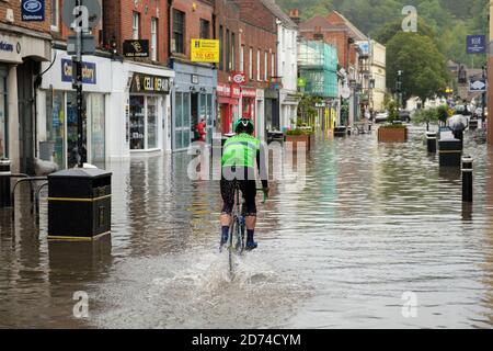 Winchester, Angleterre, Royaume-Uni 27/08/2020 UN cycliste qui traverse les eaux d'inondation sur la rue High à Winchester après de lourds dégrins dus à la tempête Francis. Banque D'Images