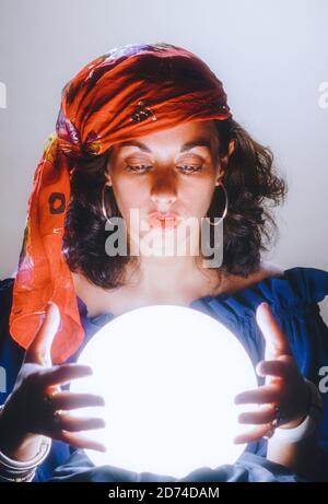 Jeune femme se concentrant plus de boule de cristal, USA Banque D'Images