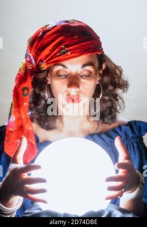 Jeune femme se concentrant plus de boule de cristal, USA Banque D'Images