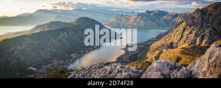 Vue sur KotorBay au coucher du soleil depuis la route de montagne en serpentin au-dessus du ciel avec des nuages au coucher du soleil. Banque D'Images