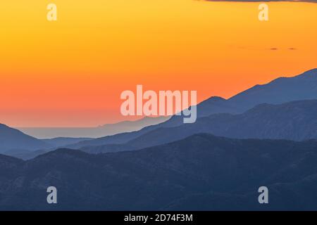 Vue sur KotorBay au coucher du soleil depuis la route de montagne en serpentin au-dessus du ciel avec des nuages au coucher du soleil. Banque D'Images