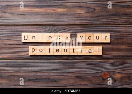 Déverrouiller votre potentiel mot écrit sur une cale en bois. déverrouiller votre potentiel de texte sur table, concept. Banque D'Images