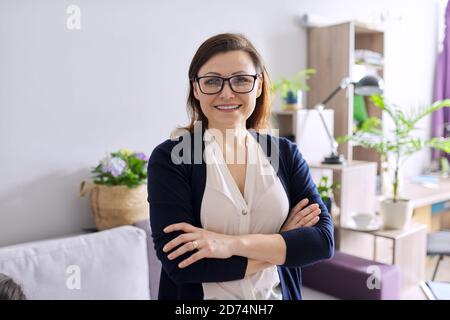 Portrait d'une femme mûre positive et confiante avec bras repliés Banque D'Images