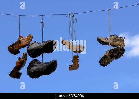 Décoration de rue Soliful : baskets et autres chaussures balançant dans la brise au-dessus d'une petite rue latérale juste à côté de la place centrale de l'université à Aix-en-Provence, Bouches-du-Rhône, Provence-Alpes-Côte d'Azur, France Banque D'Images