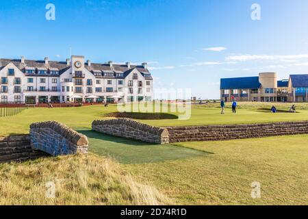 Golfeurs sur le 18ème green sur Carnoustie Championship Links parcours de golf à travers le Barry Burn et en face de Carnoustie Hotel, Carnoustie, Banque D'Images