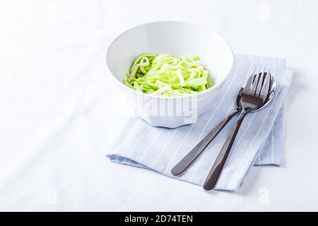 Nuddles de Zucchini sains avec pesto sur fond blanc. Placer pour le texte. Banque D'Images