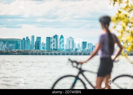 Cycliste montréalaise cycliste avec vélo regardant la vue sur l'horizon des tours d'appartement et des bâtiments du centre-ville contre le paysage du Mont Royal. En été, à l'extérieur