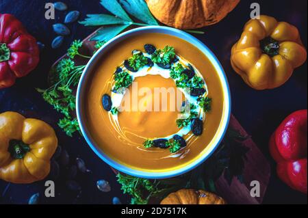 Vue de haut en bas d'un bol de soupe de citrouille avec décoration et légumes Banque D'Images