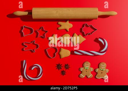 Repas de Noël. Biscuits maison de pain d'épice avec des ingrédients pour la cuisson de noël et des ustensiles de cuisine sur table rouge. Illustration 3D Banque D'Images