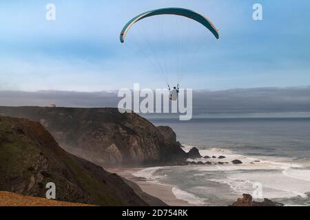 Vila do Bispo, Portugal - 12 février 2020 : un parapente survolant les falaises pittoresques de la plage de Cordoama (Praia da Cordoama) près du village de Banque D'Images