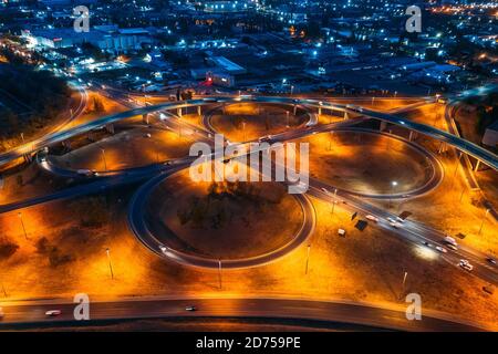 Intersection de route ou croisement de transport en ville de nuit avec ponts et circulation de voiture, vue aérienne. Banque D'Images