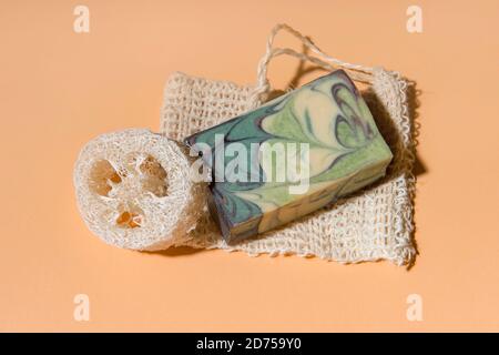 Savon fait main et éponges loofah sur fond beige. Concept de mode de vie écologique. Banque D'Images