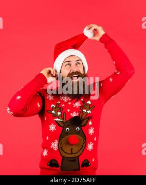 juste s'amuser. barbu brutal dans chapeau de père noël. joyeux noël. homme avec barbe sur fond rouge. ventes de noël. vêtements taille basse mûr pull en maille. bonne année. Banque D'Images